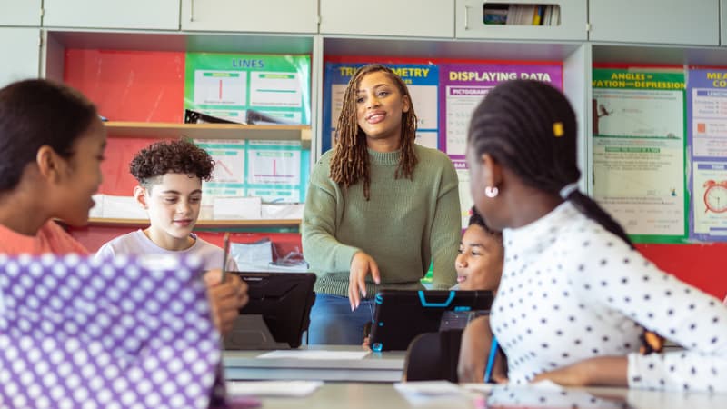 Diverse students and teacher in a modern classroom with technology integration